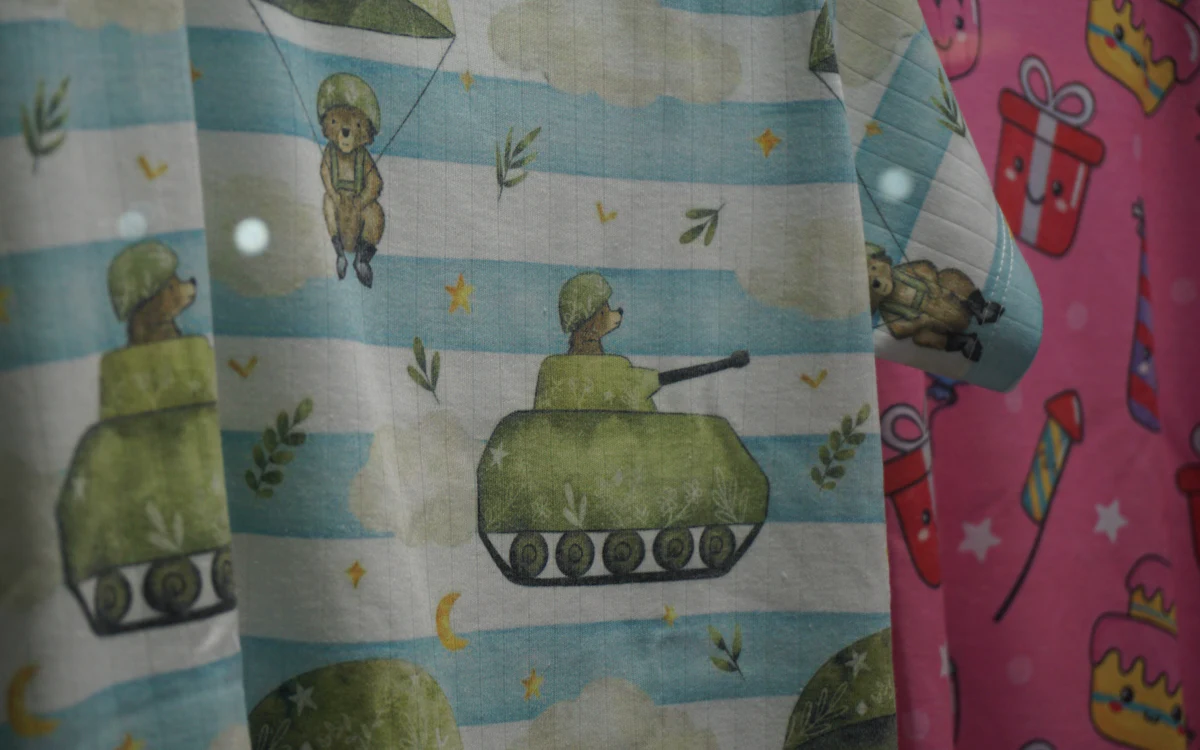 Bunter Kinderstoff mit Bären- und Panzer-Motiv.