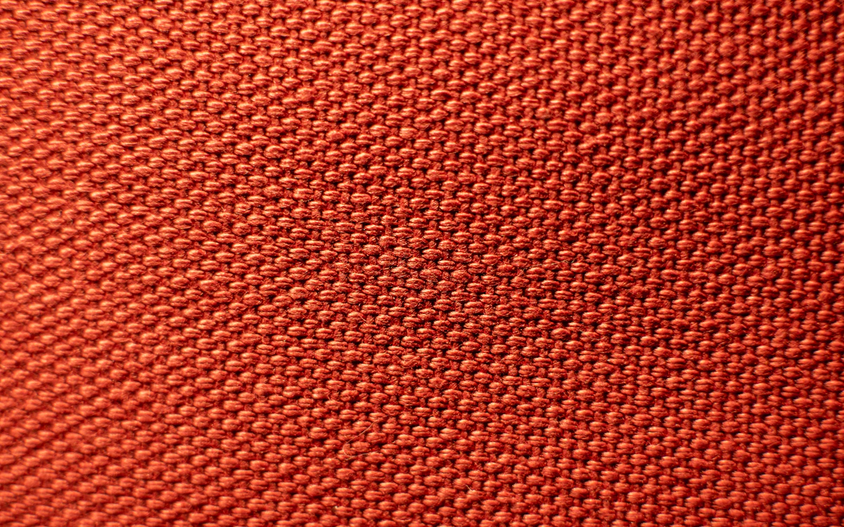 Rot-orangefarbene Maschenware in Nahaufnahme.